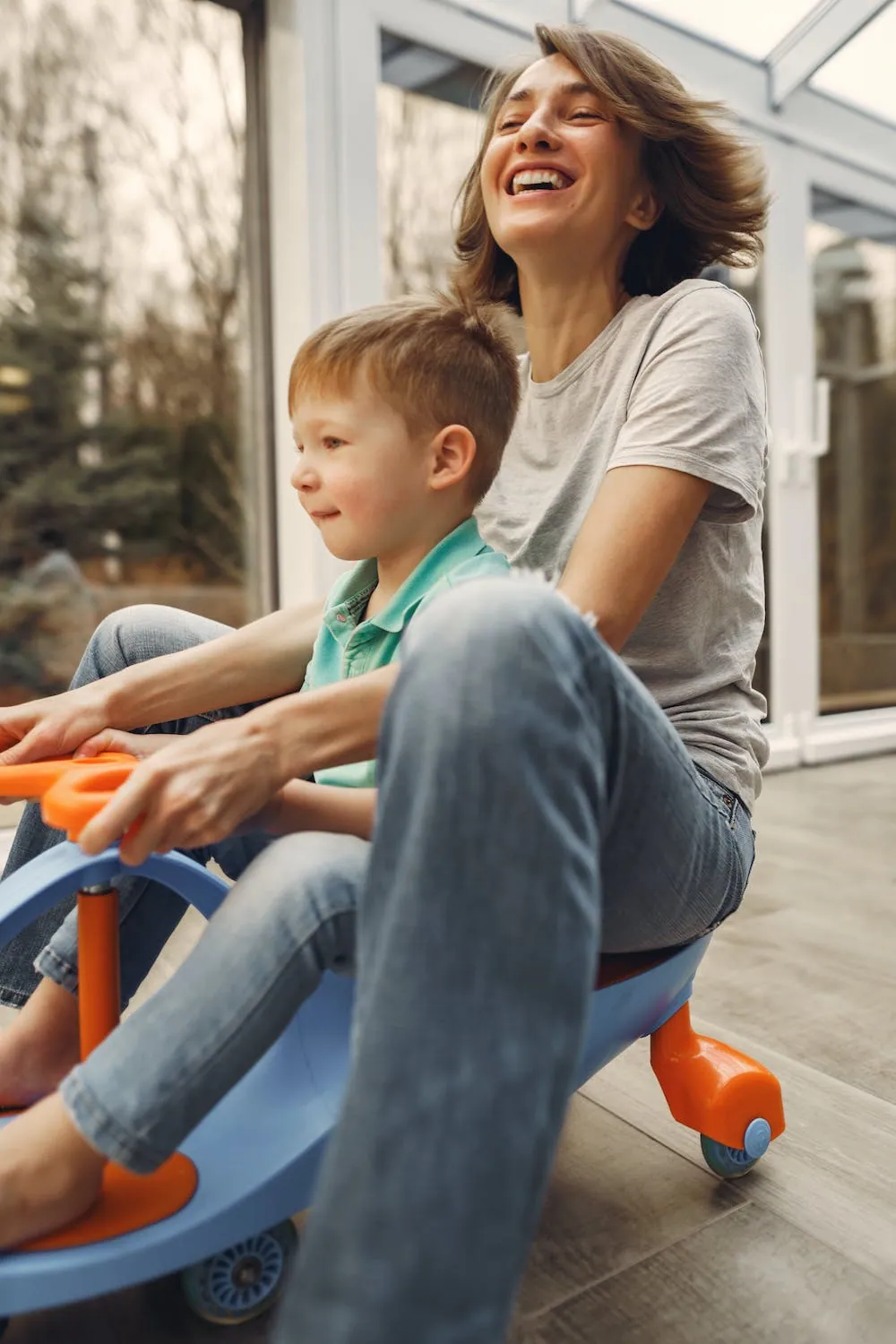 mom on scooter with son laughing